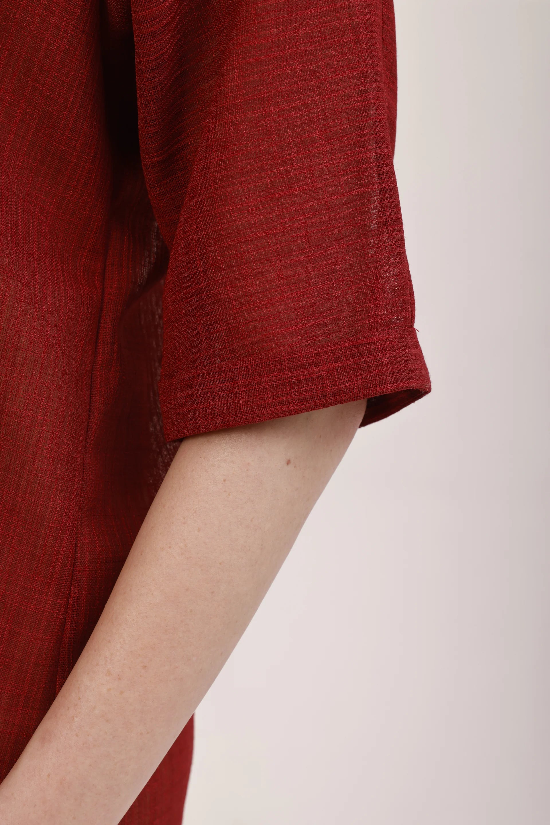 Détail de la manche courte de La robe chemise Garance, texture du polyester recyclé rouge Rivage Bleu