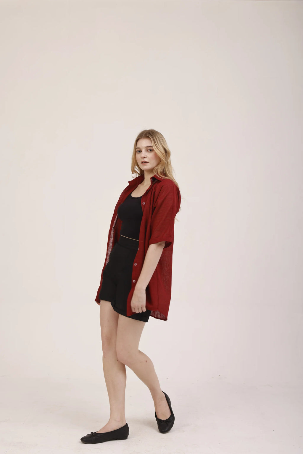 La robe chemise Garance portée ouverte sur une tenue noire, veste-chemise rouge Rivage Bleu en polyester recyclé